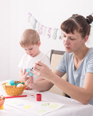 Religious holidays: Mom and son paint Easter eggs.