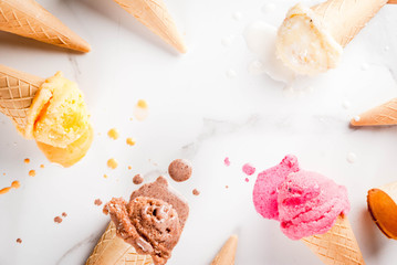 Homemade chocolate, vanilla, berry ice cream in ice cream cones, white marble background copy space top view frame