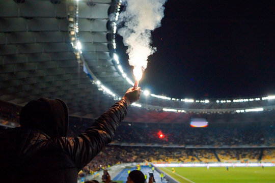 football fans are holding torches in fire during a match