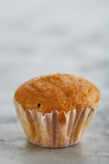 Tasty muffins arranged in pattern on light textured background, close-up, shallow depth of field, selective focus.