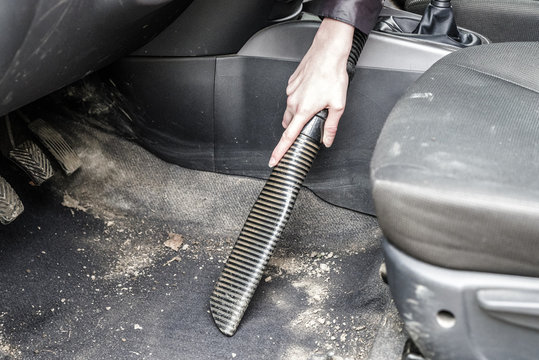 Woman Cleaning Interior Of Car With Vacuum Cleaner