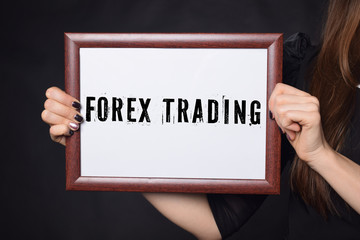 In the hands of a businessman a frame with the inscription:FOREX TRADING