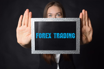 In the hands of a businessman a frame with the inscription:FOREX TRADING