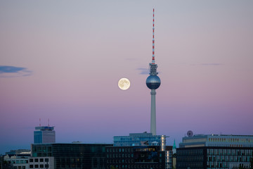 Berlin's TV tower with a full moon at sunset