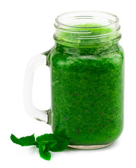 Healthy green smoothie with straw in a jar mug isolated on white