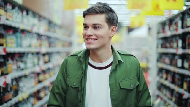 Close up smiling man walk with shopping cart at the supermarket feel happy hypermarket hand food shop store customer grocery handsome indoor lifestyle male market buyer guy product shopper slow motion