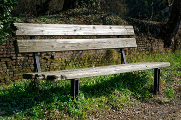 One wooden bench on sunny day in Italy, public parkland