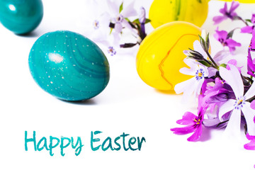 close-up of colorful easter eggs and phlox flowers on white background with copy space. border template, easter greeting and holiday card.