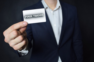 Businessman shows business card with the inscription:FOREX TRADING
