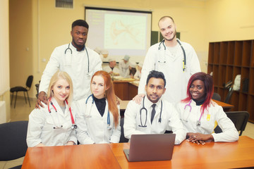 Fototapeta na wymiar A group of young medical students with mixed-race surgeons examining these operations in a laptop