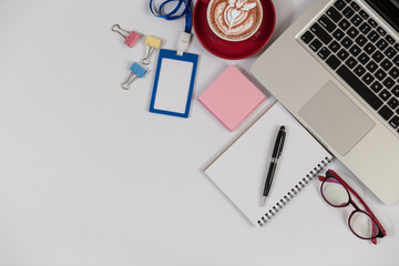 White Office desk table with laptop,smartphone and coffee cup and accessories. Business desk with a keyboard, mouse and pen on white table. Top view of workplace