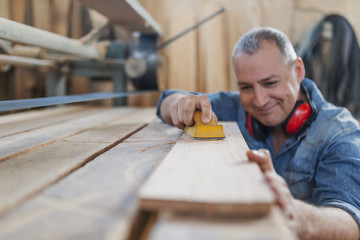 Portrait of handsome precise cabinetmaker during work in workshop