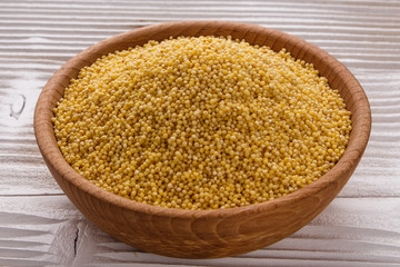 bowl of millet on a white wooden background