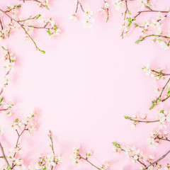 Frame of spring flowers isolated on pastel background. Flat lay, top view. Spring time background.