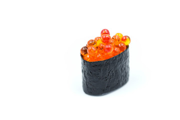 Salmon egg on sushi nigiri roll on white background.