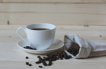 A cup of black coffee and coffee beans