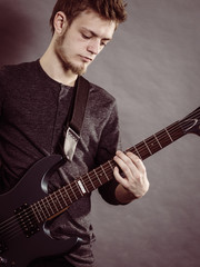 Obraz premium Young man playing electric guitar