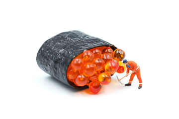 Miniature people : worker with Salmon egg on sushi nigiri roll on white background.