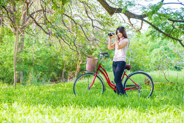 Obraz premium Beautiful women leisure in park with red bike
