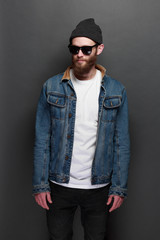 Fototapeta premium Hipster handsome male model with beard wearing white blank t-shirt and a baseball cap with space for your logo or design in casual urban style
