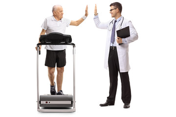 Senior walking on a treadmill and high-fiving a doctor