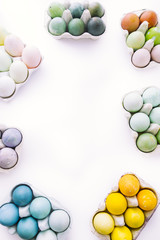Happy easter! conceptual photo with a white background and sets of eggs colored using natural ingredients  creating a border easter!