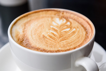 Cappuccino in a white cup on restaurant table