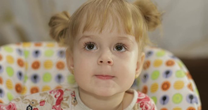Beautiful two years old girl. Cute blonde child. Brown eyes. Close up