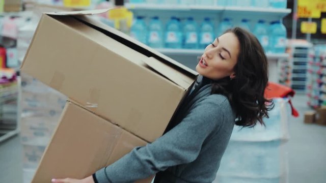 woman carries heavy boxes heavily inhaled hurry in a supermarket thinking shopping internet buy technology hypermarket shop mall smartphone grocery market girl food customer slow motion