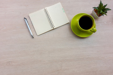 Office desk wood table with notebook and coffee cup, Top view with copy space.