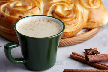 Homemade rose bread, cup of coffee, anise and cinnamon on white textured background, close-up, shallow depth of field