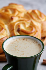 Homemade rose bread, cup of coffee, anise and cinnamon on white textured background, close-up, shallow depth of field