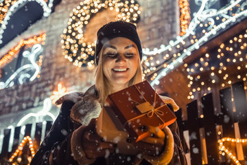 Portrait of young happy girl when opening his Christmas present. Christmas, holidays, winter and people concept