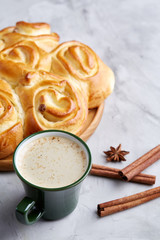 Homemade rose bread, cup of coffee, anise and cinnamon on white textured background, close-up, shallow depth of field