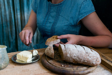 Woman puts butter on rye bread breakfast concept