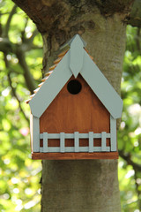 Obraz na płótnie Canvas A Small Wooden Bird Nest Box Fixed to a Tree Trunk.