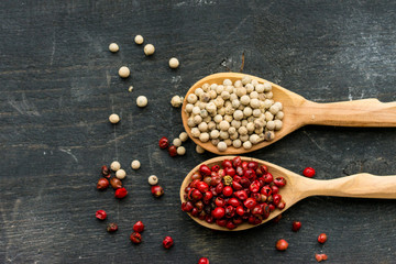 Two wooden spoons with pink and white peppercorn