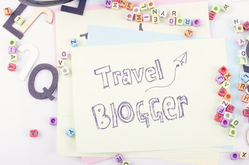 TRAVEL BLOGGER word written on yellow paper and decorative items
