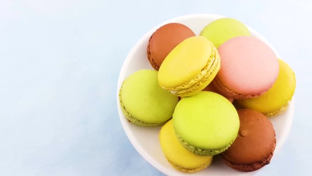 Macaroons or macaron on pastel blue surface. Close up.