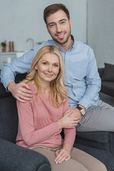 portrait of smiling grown son and mother at home