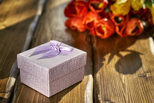 Gift box and flowers on the wooden table