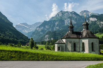 Fototapeta na wymiar A scenic view of an ancient Holzkapelle church under the Alps mountains in Engelberg valley, Switzerland