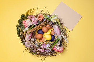 Easter card. Painted Easter eggs in nest on yellow background