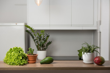 Fototapeta na wymiar Avocado, mango and kiwi on the table in kitchen interior. Healthy vegetarian lifestyle concept. Copy space