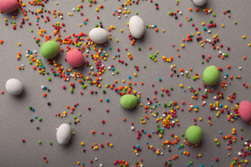 Various sweets and colorful sprinkles on gray table