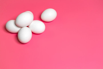 Minimal Easter concept. Top view. White eggs on pink background. Close up. Copy space. Flat lay.
