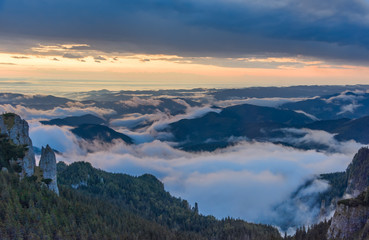 Beautiful mountain view with fog over the peaks at sunrise, Ceahlau massif, Eastern Carpathians, Moldova, Romania