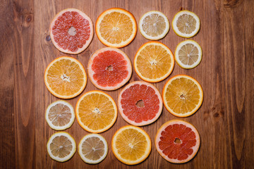 Citrus fruit cut in half - oranges, lemons, tangerines, grapefruit on a wooden background