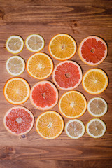 Citrus fruit cut in half - oranges, lemons, tangerines, grapefruit on a wooden background