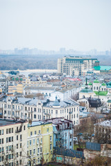 City of Kyiv (Kiev), capital of Ukraine, panorama. Colorful houses and Dnipro river on a background. Cloudy spring afternoon. Filtered.